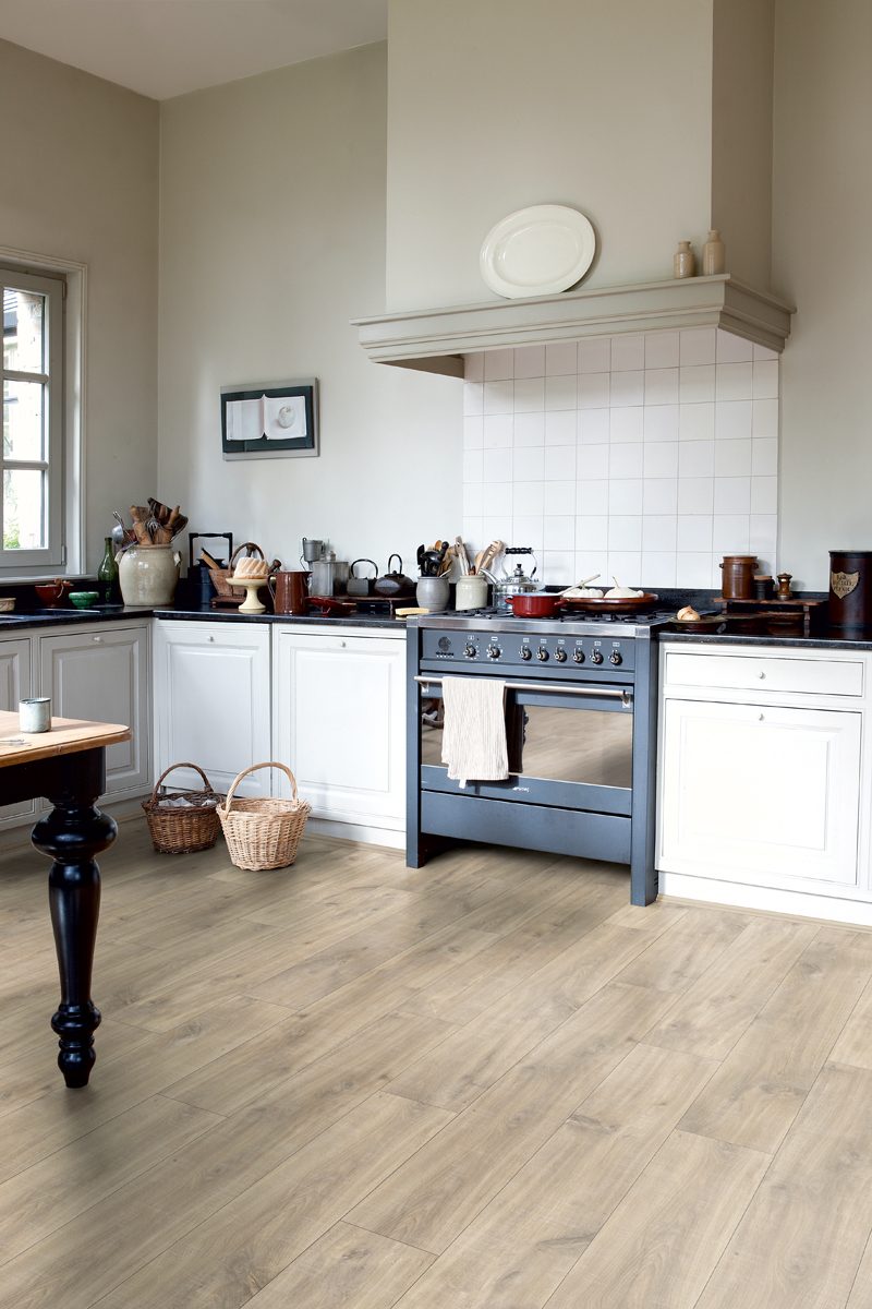 A kitchen with wide laminate floor planks
